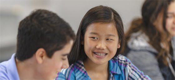 Pre-teen children engaging in a classroom.