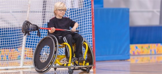 Child in a wheelchair playing lacrosse