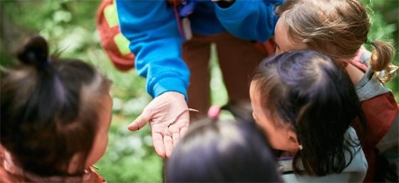 Children looking at a worm in the instructors hand