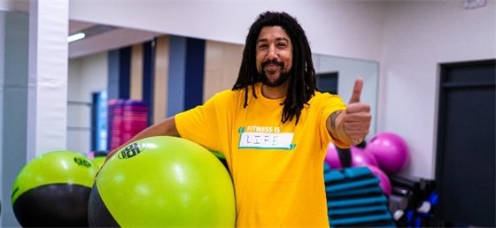 Adult in fitness centre giving a thumbs up
