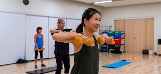 Adult lifting weights in fitness class