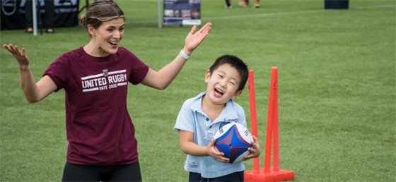 Adult and child playing rugby 
