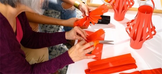 People creating red paper lanterns