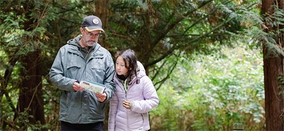 Father and daughter navigating a Coquitlam trail with a map in hand.