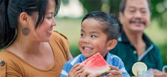 Adult and child holding watermelon