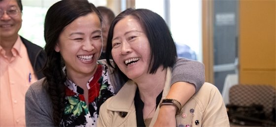 Two adults laughing and hugging