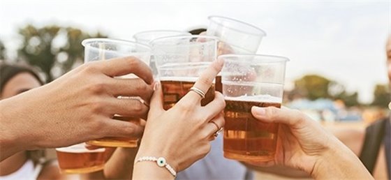 Cheers with plastic cups of beer 