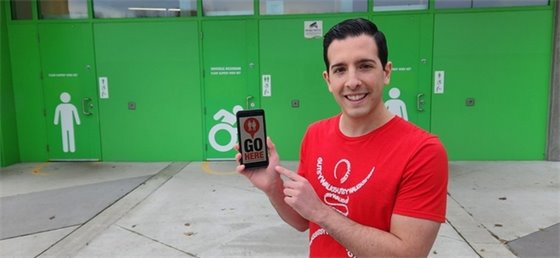 Adult holding a cell phone with the GoHere App on the screen