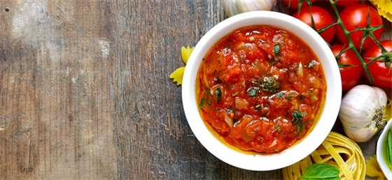 Red soup in a bowl with ingredients surrounding
