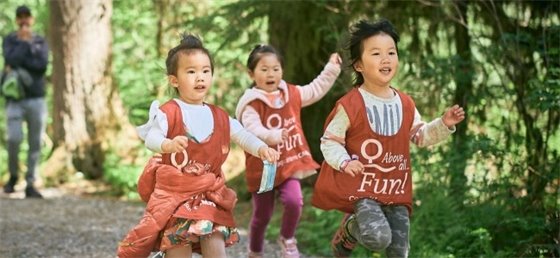 Three kids running in a forest