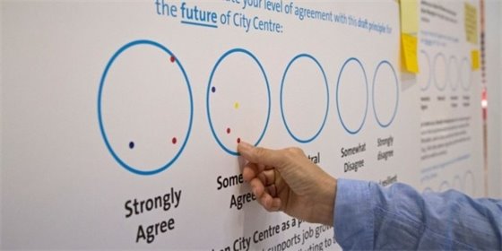 A person places a dot to indicate their support for a draft principle of the City Centre Area Plan