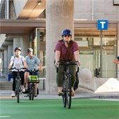 Three people bike across a multi-modal pathway.