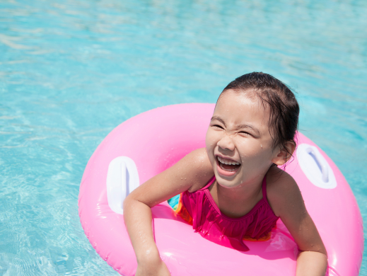Child in a pink tube in the water