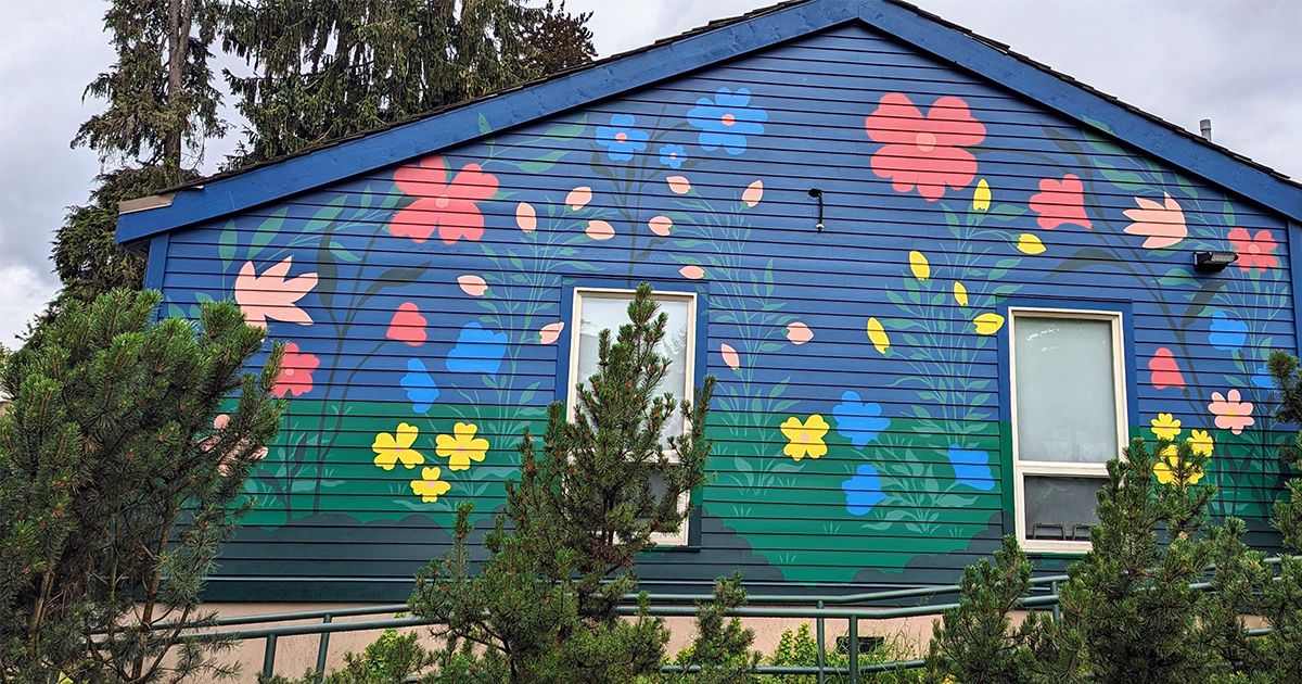 Mural on side of house: red, blue, yellow and pink flowers against navy background background