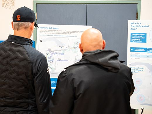 A photo of two men looking at display boards from an information session. 