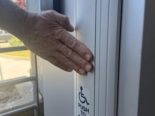 Hand pressing power bar on door.
