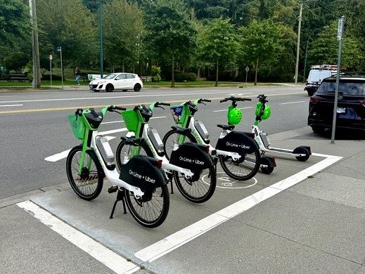 Lime shared e-bikes and e-scooters parked in a parking station on a sidewalk 