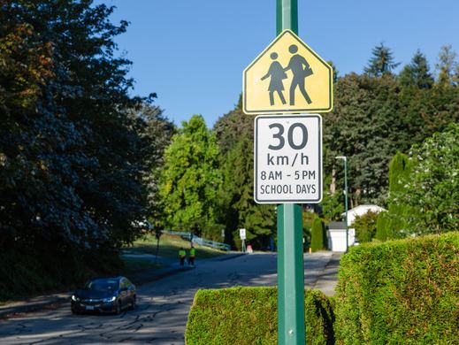 Regulatory street sign showing 30 km/h speed limit in school zone