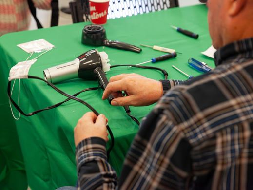 A person repairing a hair dryer at the Coquitlam Repair Cafe