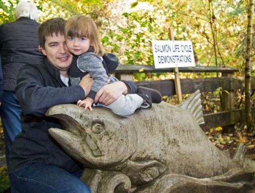 Parent and child by salmon sculpture 