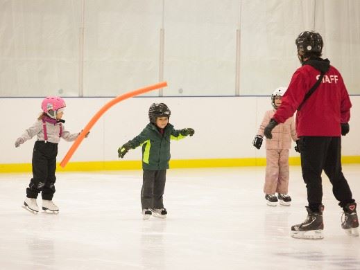 Three kids skating with instructor