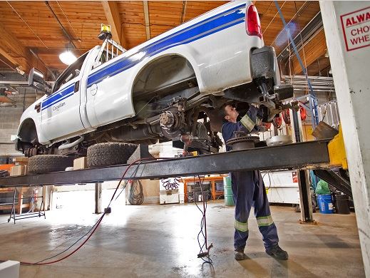 City of Coquitlam Public Works Crew member repairs a white City of Coquitlam-branded truck