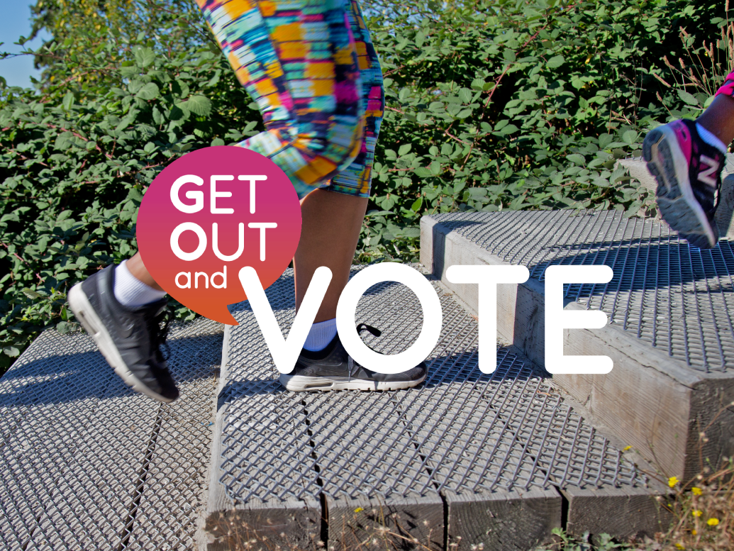 The words "Get out and Vote" overlay the feet of a person climbing the Coquitlam Crunch