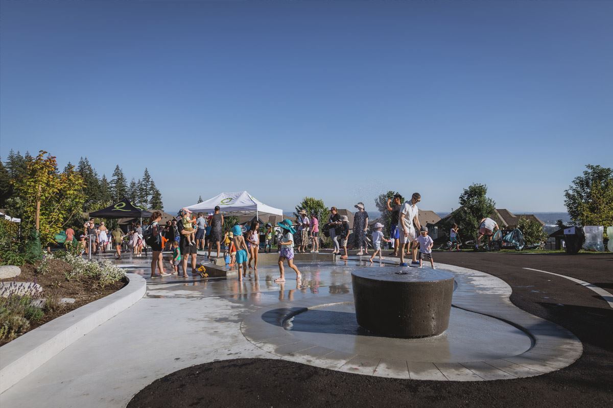 Children and parents playing in the spray park. 