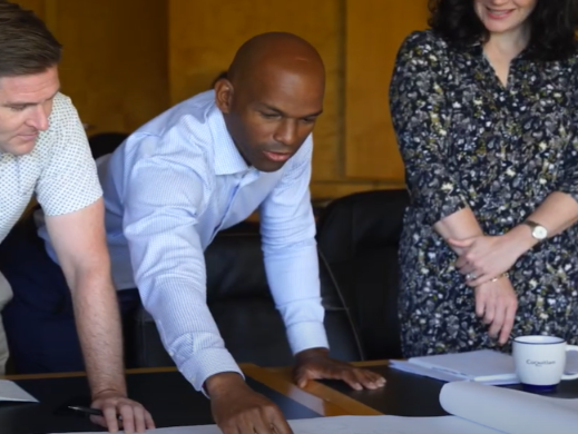 A group of working professionals reviewing documents on a table