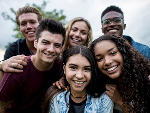 A group of teens smile for a photo