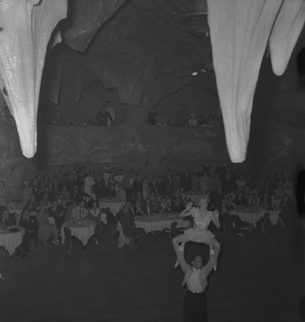 Large group watching unidentified performers at the Cave Supper Club