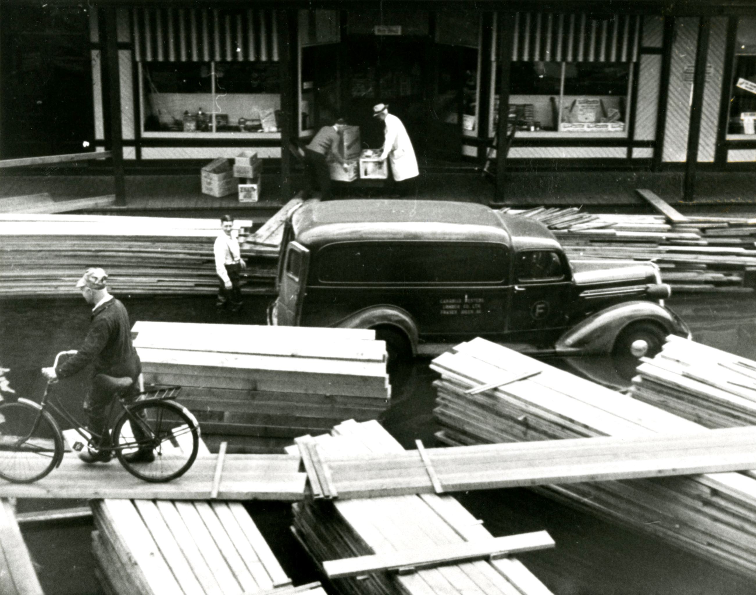 Makeshift lumber walkways at the Fraser Mills General Store during the 1948 flood (Source City of Co Opens in new window